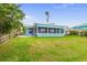 Charming light blue waterfront home with a screened-in porch and lush lawn for relaxing outdoor enjoyment at 525 Lillian Dr, Madeira Beach, FL 33708
