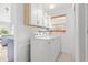 A laundry room with washer, dryer, storage cabinets, and a window for natural light at 525 Lillian Dr, Madeira Beach, FL 33708