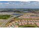 Scenic aerial view showcasing a community with single-Gathering homes bordering tranquil lakes and lush surroundings at 5329 Windy Grove Dr, Wimauma, FL 33598