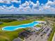 A stunning aerial view of a community lagoon area with sandy beaches and recreational facilities at 5329 Windy Grove Dr, Wimauma, FL 33598