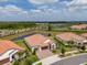 Wide aerial view of a residential area featuring tile roofs and a serene pond, highlighting community living at 5329 Windy Grove Dr, Wimauma, FL 33598