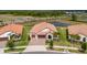 Impressive aerial view of a tile roof home near a peaceful pond, showcasing its well-maintained landscaping at 5329 Windy Grove Dr, Wimauma, FL 33598