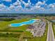 An aerial view shows a long, blue lagoon surrounded by green landscape and neighborhood housing at 5329 Windy Grove Dr, Wimauma, FL 33598