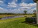 Well-maintained backyard featuring a tranquil pond view, surrounded by lush green grass and serene landscaping at 5329 Windy Grove Dr, Wimauma, FL 33598