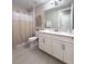 Clean bathroom featuring a shower with curtain, white cabinets, and a large mirror at 5329 Windy Grove Dr, Wimauma, FL 33598