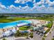 Aerial view of community pool and recreation area with parking, clubhouse, and sandy beach area at 5329 Windy Grove Dr, Wimauma, FL 33598
