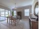 Bright dining area with a stylish table setting, modern chandelier, and sliding doors to the outdoor space at 5329 Windy Grove Dr, Wimauma, FL 33598