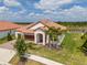 Aerial view of a tile roofed home with a lush lawn, water feature, and mature landscaping at 5329 Windy Grove Dr, Wimauma, FL 33598