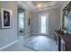 Bright foyer featuring a decorative light fixture, tiled floors, and views into the adjacent bedroom at 5329 Windy Grove Dr, Wimauma, FL 33598