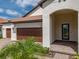 Inviting front porch with brick pavers and an arched entryway leading to the stylish blue front door at 5329 Windy Grove Dr, Wimauma, FL 33598