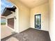 Inviting front porch with brick pavers and an arched entryway leading to the stylish blue front door at 5329 Windy Grove Dr, Wimauma, FL 33598