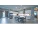 Spacious kitchen with white cabinets, stainless steel appliances, large center island, and pendant lighting at 5329 Windy Grove Dr, Wimauma, FL 33598