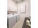 Bright laundry room features upper cabinets, a countertop, and a modern washer and dryer at 5329 Windy Grove Dr, Wimauma, FL 33598