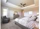 Bright main bedroom with large bed, dresser and sitting area and a beautiful tray ceiling at 5329 Windy Grove Dr, Wimauma, FL 33598