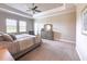 Bright main bedroom featuring a soft gray color scheme, dresser, and natural lighting from the windows at 5329 Windy Grove Dr, Wimauma, FL 33598