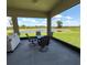 Enclosed patio boasts stunning views of the pond and manicured lawn, complete with comfortable outdoor seating at 5329 Windy Grove Dr, Wimauma, FL 33598