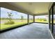 Spacious covered patio overlooks lush landscaping, tranquil pond, and beautiful blue sky at 5329 Windy Grove Dr, Wimauma, FL 33598