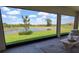 Expansive screened lanai showcasing a serene view of the pond, lawn, and lush landscaping at 5329 Windy Grove Dr, Wimauma, FL 33598
