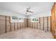 A spacious bedroom with natural light, ceiling fan, and exposed wall studs ready to be customized at 5921 Denver Ne St, St Petersburg, FL 33703