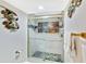 Modern bathroom with walk-in shower with pebble floor and beachy artwork at 6035 Sea Ranch Dr # 612, Hudson, FL 34667