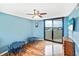 Cozy bedroom with a ceiling fan, a balcony, and a charming blue accent wall at 6035 Sea Ranch Dr # 612, Hudson, FL 34667