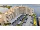 Waterfront condo building with covered parking, lush landscaping, and water views at 6035 Sea Ranch Dr # 612, Hudson, FL 34667