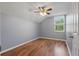This bright bedroom features wood-look floors and a window overlooking the yard at 6616 Northhaven Ct, Riverview, FL 33578