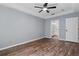 A spacious main bedroom featuring wood floors, tray ceilings, ceiling fan, and an ensuite bath at 6616 Northhaven Ct, Riverview, FL 33578