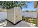 Close up view of storage shed, concrete pad, and fenced yard at 6616 Northhaven Ct, Riverview, FL 33578