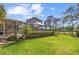Expansive backyard featuring a screened lanai, lush greenery, and picturesque views of the surrounding landscape at 6790 Burning Tree Dr, Seminole, FL 33777