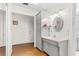 Traditional bathroom featuring a grey vanity, oval mirror and wood-look flooring at 6790 Burning Tree Dr, Seminole, FL 33777
