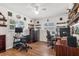 Home office with built-in shelves, two desks, shuttered windows and wood floors at 6790 Burning Tree Dr, Seminole, FL 33777