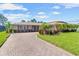 Charming home featuring a brick driveway, lush landscaping, and well-maintained lawn at 6790 Burning Tree Dr, Seminole, FL 33777