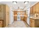 Bright kitchen featuring wood cabinets, granite counters, and modern appliances with tile flooring at 6790 Burning Tree Dr, Seminole, FL 33777