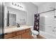 Neutral toned bathroom featuring a large mirror, wood vanity, a toilet and shower/tub combination at 6851 Breezy Palm Dr, Riverview, FL 33578