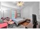 Cozy bedroom with natural light, a patterned bedspread, and warm hardwood floors at 6851 Breezy Palm Dr, Riverview, FL 33578