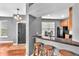 View of a kitchen with bar seating that looks into the entryway of the home with gray walls and wood floors at 6851 Breezy Palm Dr, Riverview, FL 33578