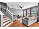 Living room featuring hardwood floors, modern furniture, staircase, and large windows with curtains at 6851 Breezy Palm Dr, Riverview, FL 33578