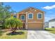 Charming two-story home featuring an attached garage and a well-manicured lawn with vibrant landscaping at 7102 W Creek Dr, Tampa, FL 33615