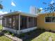 A screened in back porch featuring a sun roof with plants, and a view of the grass in the backyard at 844 67Th S St, South Pasadena, FL 33707
