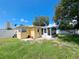 Yellow home's backyard featuring a screened-in porch and a white fence at 844 67Th S St, South Pasadena, FL 33707