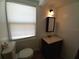 This bathroom features a dark vanity, toilet, and a window at 844 67Th S St, South Pasadena, FL 33707