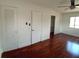 Spacious bedroom with hardwood floors, ceiling fan, closet, and natural light from the window at 844 67Th S St, South Pasadena, FL 33707