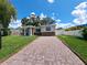 Paver driveway leading up to a charming home featuring stone accents under the windows under a blue sky at 844 67Th S St, South Pasadena, FL 33707