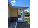 Close up view of a home's columned entry with stacked stone accent and yellow siding at 844 67Th S St, South Pasadena, FL 33707