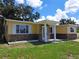 Charming home with a covered front porch featuring stone accents under the windows and large windows with white trim at 844 67Th S St, South Pasadena, FL 33707