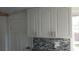 Updated kitchen cabinets with decorative tiled backsplash at 844 67Th S St, South Pasadena, FL 33707