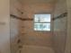 Updated bath/shower with tiled surround and decorative accent tiles at 844 67Th S St, South Pasadena, FL 33707