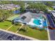 Aerial view of community center with swimming pool, shuffleboard court, and well-manicured lawns at 854 Sky Loch N Dr, Dunedin, FL 34698