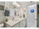 Bathroom with double sink vanity, framed mirror, coordinated fixtures, and coastal decor at 854 Sky Loch N Dr, Dunedin, FL 34698